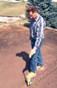 Man using a Battery-Operated hand planter to plant a garden